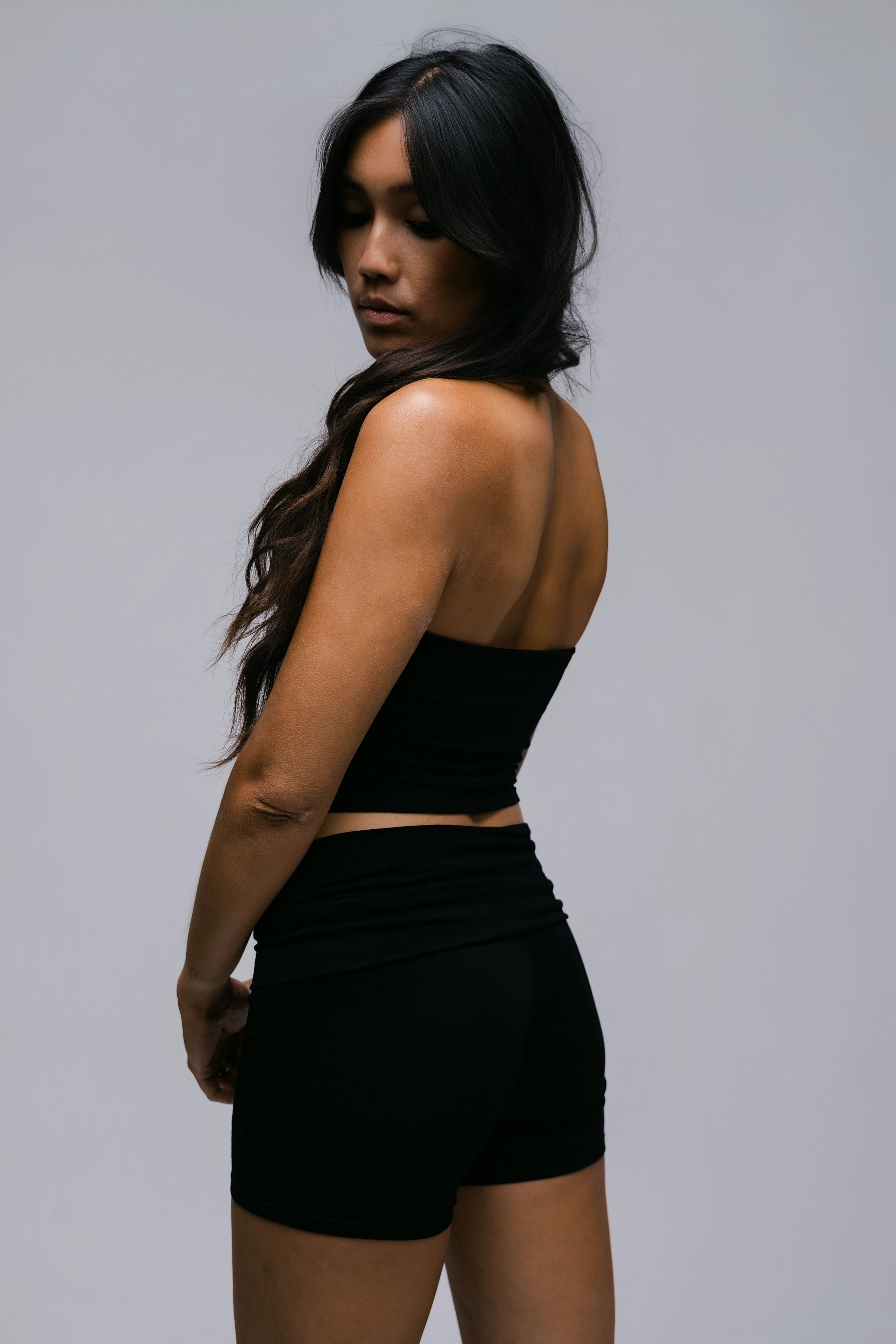 Model wearing the Billy Sculpt Short in black, three-quarter view.